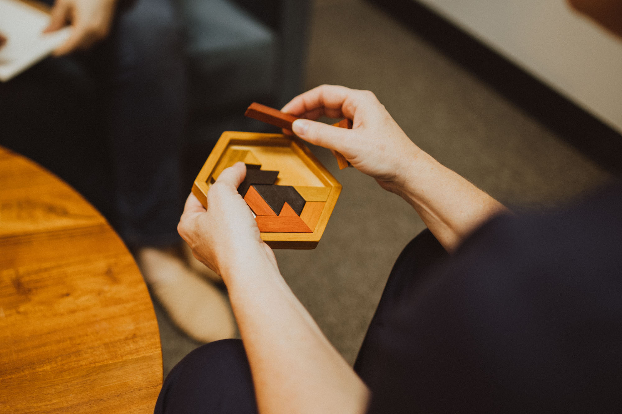 hands playing with wooden puzzle during therapy session