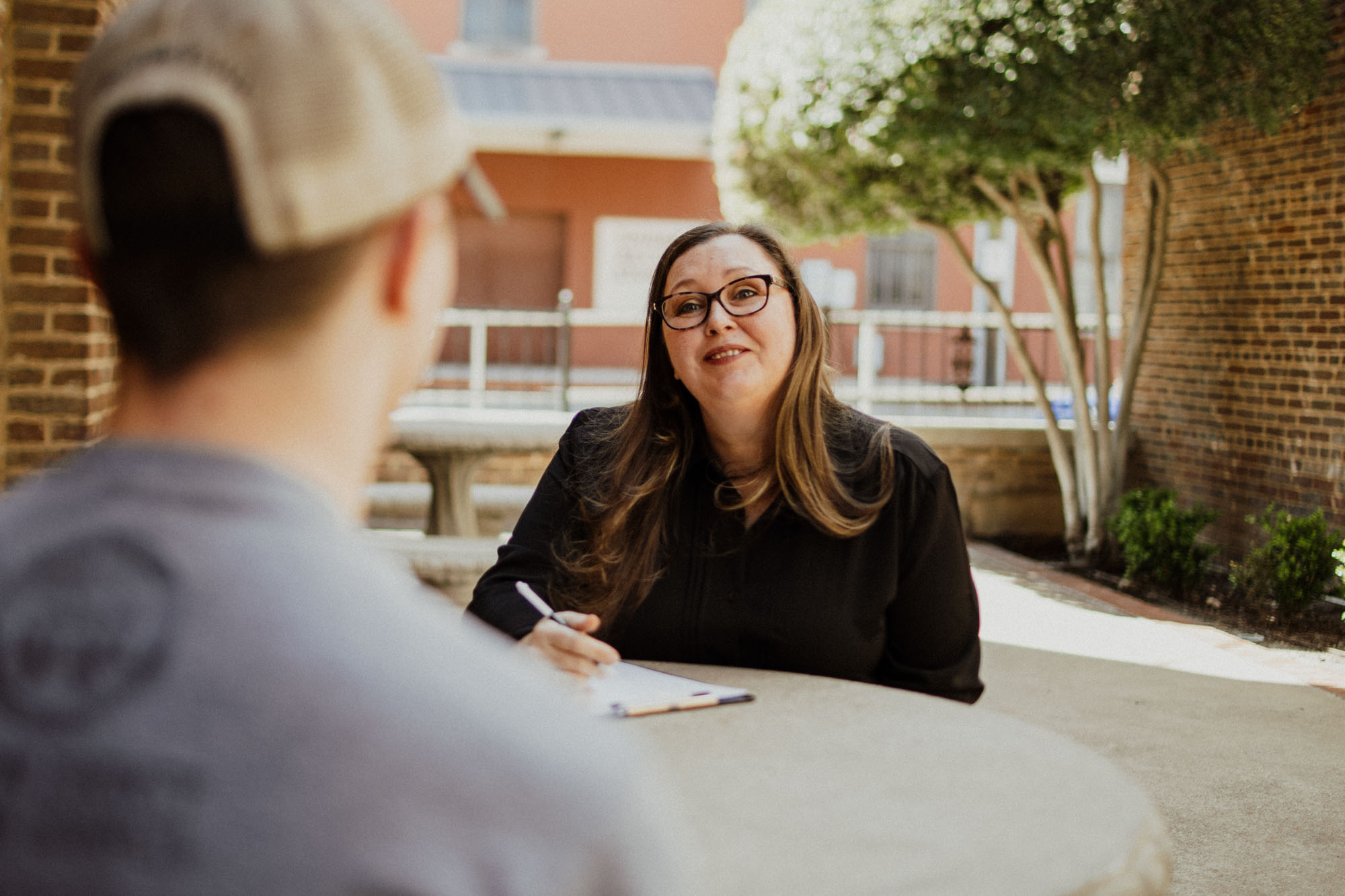 provider smiling with therapy patient outside and taking notes