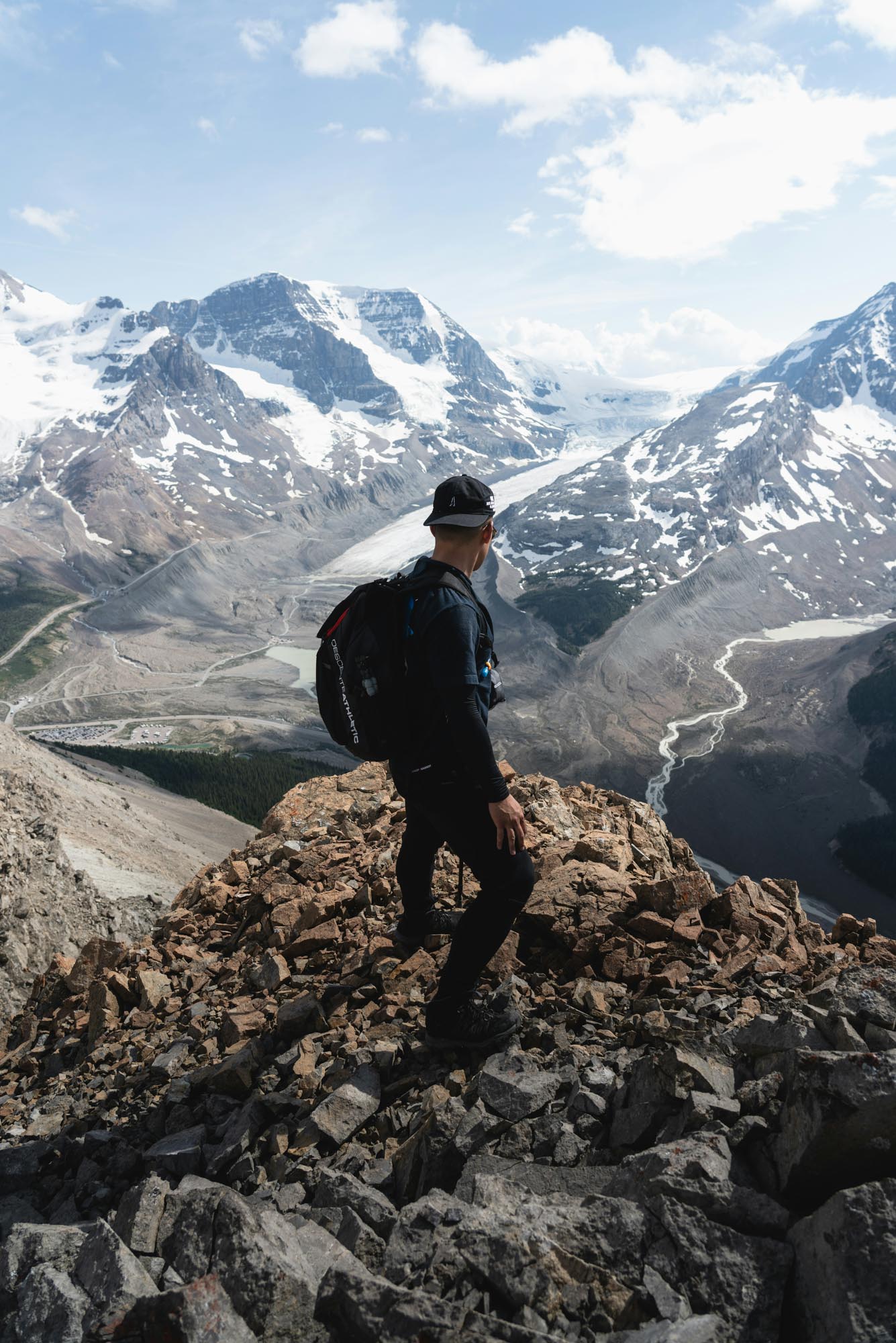 man looking at mountains while standing on top mountain