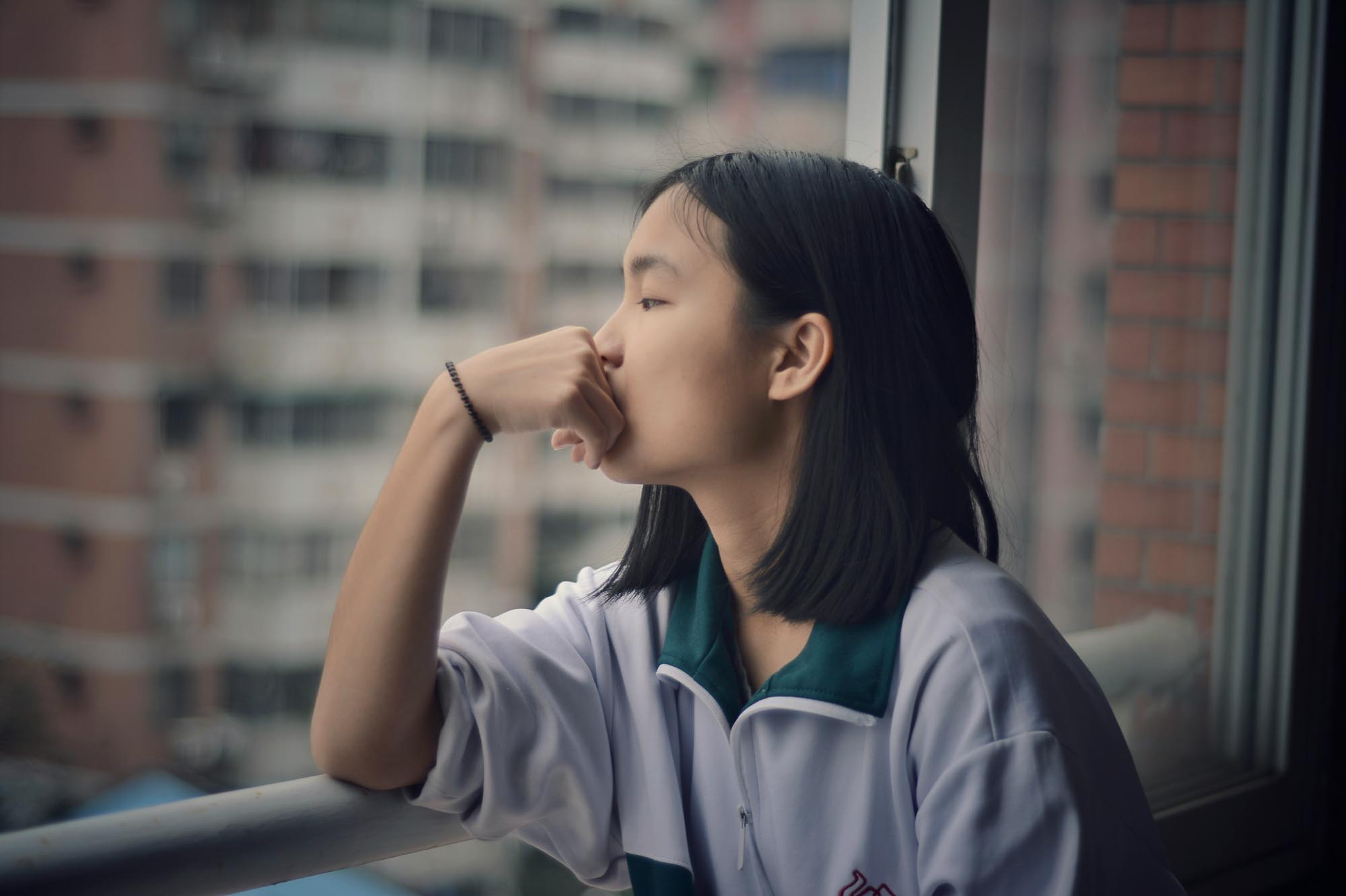 depressed youth girl looks out window