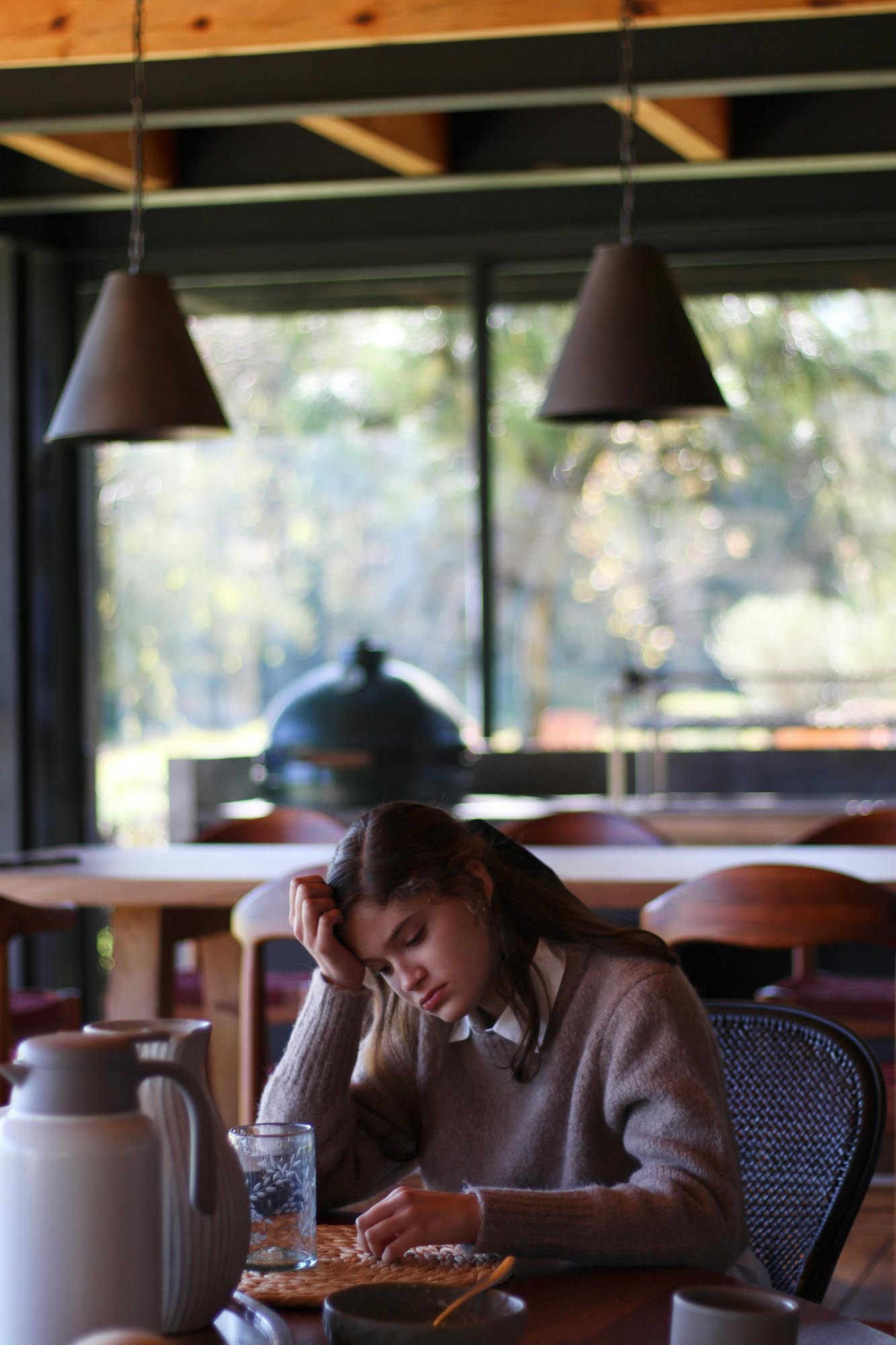 woman sits at cafe looking depressed